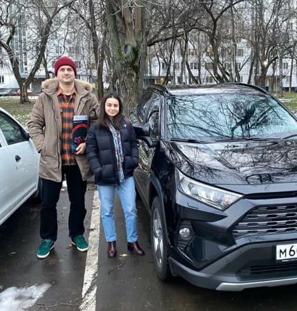 Фото - Двое людей рядом с автомобилем на улице.