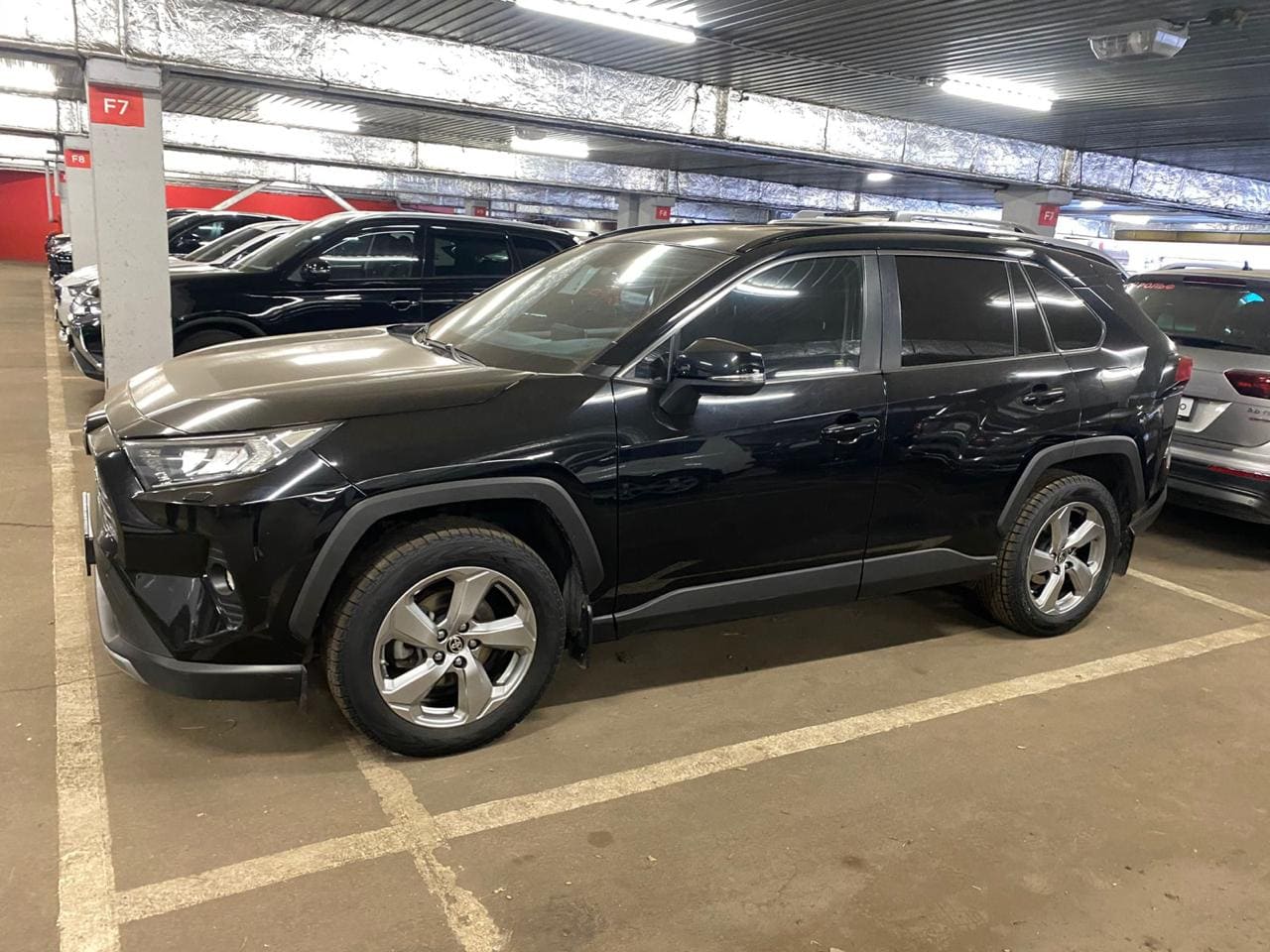 Фото - Черный SUV в гараже на парковке.