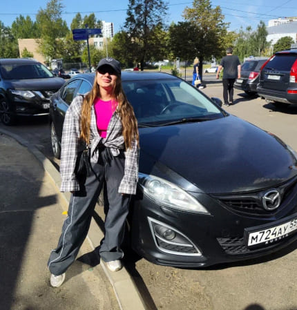 Фотография - Девушка с теннисной ракеткой рядом с автомобилем на парковке