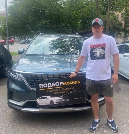 Фотография - Мужчина рядом с автомобилем KIA и рекламным баннером на переднем стекле