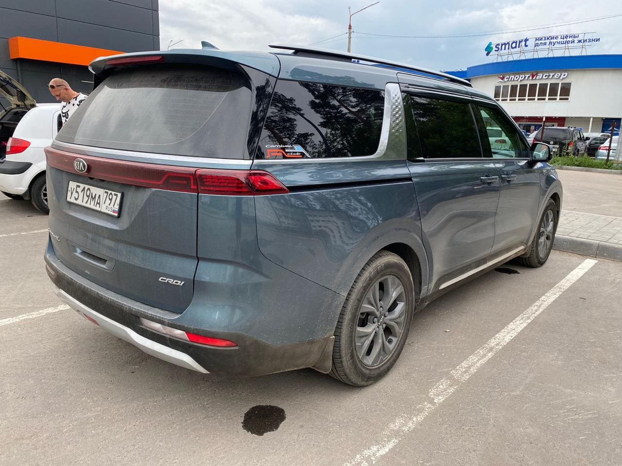 Фотография - Серый кроссовер KIA на парковке у торговых центров
