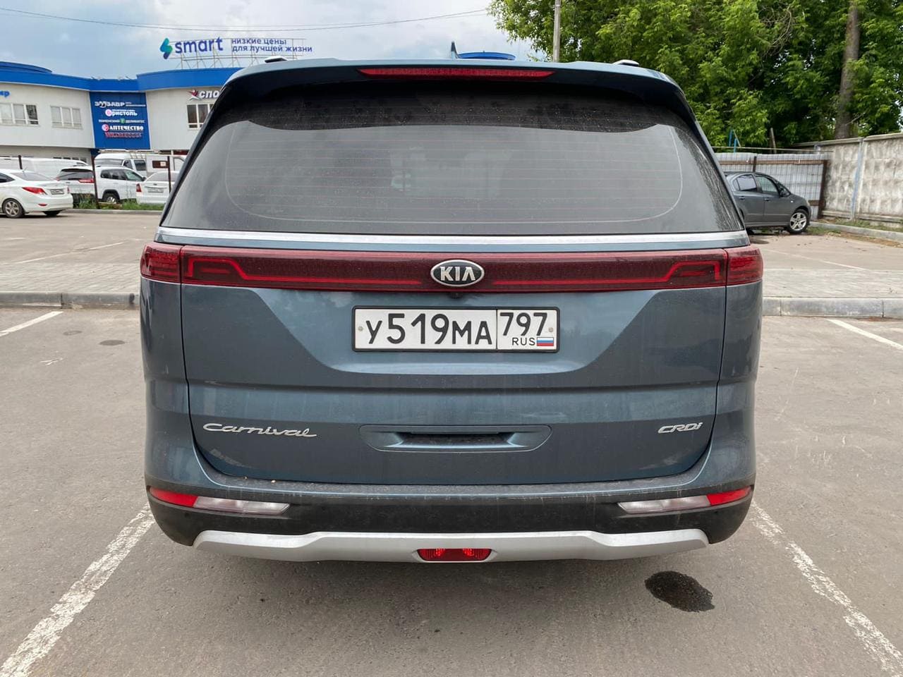 Фотография - Задняя часть автомобиля Kia Carnival на парковке